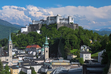 Obraz premium Salzburg, Austria. Hohensalzburg fortress on top of Festungsberg mountain, and church towers of Salzburg Old Town. View from observation point at Monchsberg mountain.