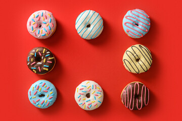 Frame made of different sweet donuts on red background