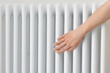 A Female Warms Hands over a Battery, a Heater at Home in a Room. Fingers, palms keeping warm from...