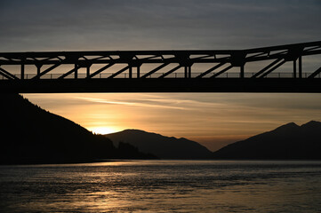 Ballachulish Bridge in Scottish Highlands at sunset with loch and mountains in view.