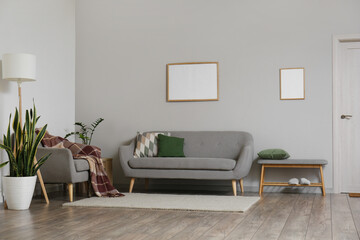 Interior of modern living room with grey sofa, armchair and standing lamp