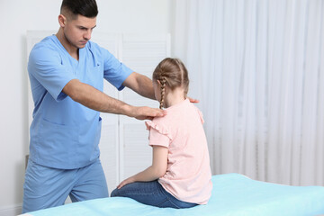 Obraz premium Orthopedist examining child in clinic. Scoliosis treatment