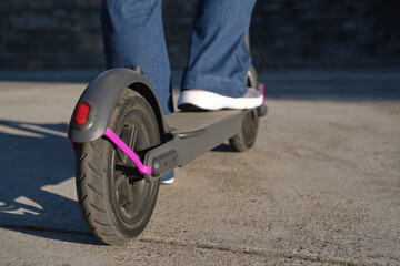 Close-up image, woman feet with her electric kick scooter in the city