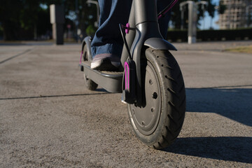 Close-up image, woman feet with her electric kick scooter in the city