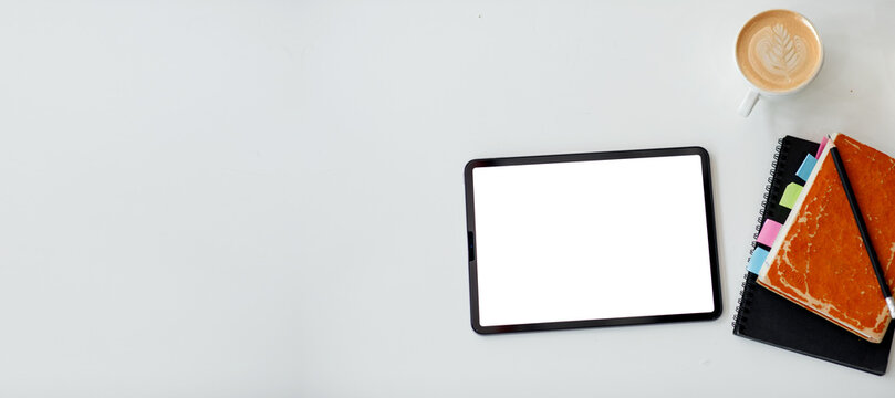Digital tablet screen on a wooden background, note coffee cup business desk with blank white screen,
