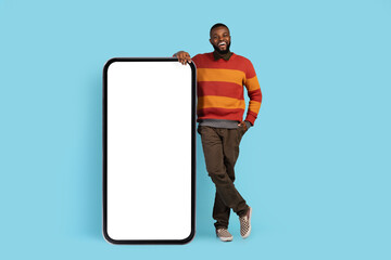 Mobile Mockup. Happy Young Black Male Leaning At Big Blank Smartphone