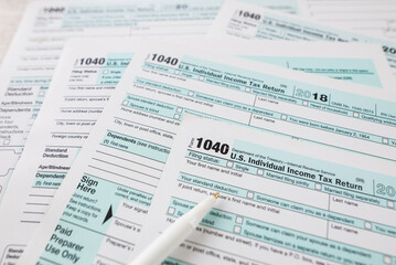 Fototapeta premium US tax form 1040 on a wooden table. Concept of tax forms 1040.