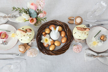 Obraz na płótnie Canvas Beautiful Easter setting with flowers on light tablecloth