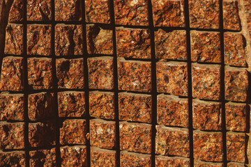 cut rough granite surface, crossing lines, background of brown red boulder rock