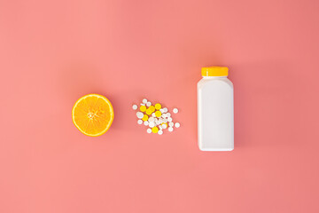 Scattered pills on pink background, orange, vitamin c concept, flat lay.