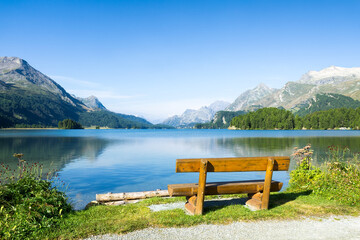 Wooden bench at Lake Sils in summer, Upper Engadin, Switzerland