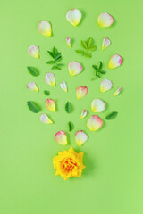 Floral arrangement, web banner with yellow roses, and leaves on green table background. Minimalistic concept for the spring holidays.