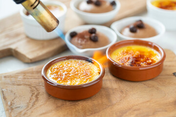 creme brûlée vanilla dessert sugar crust being caramelised with torch other dessert on background