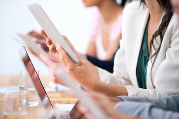 Wireless freedom in the boardroom. Cropped shot of a group of businesspeople using their wireless devices during a meeting.