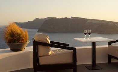 Sunset destinatino with two wine glasses at Oia, Santorini