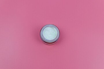Face cream on a pastel pink background. Top view