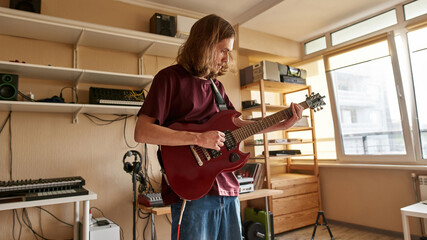 Concentrated man playing electric guitar at home