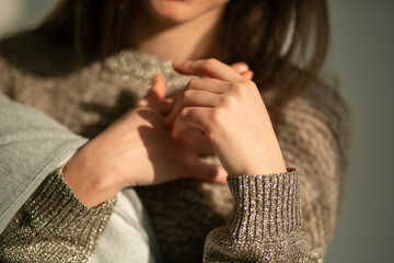 Hands of beautiful skinny brunette girl holding clothes on her hand
hands of a young girl in the foreground beautiful skin manicured hands
