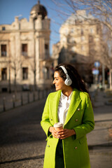 Young woman listening music with headphones on the street