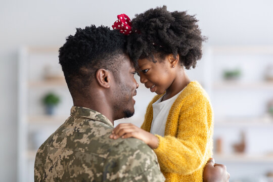 Portrait Of Black Cute Little Girl Embracing With Her Military Father