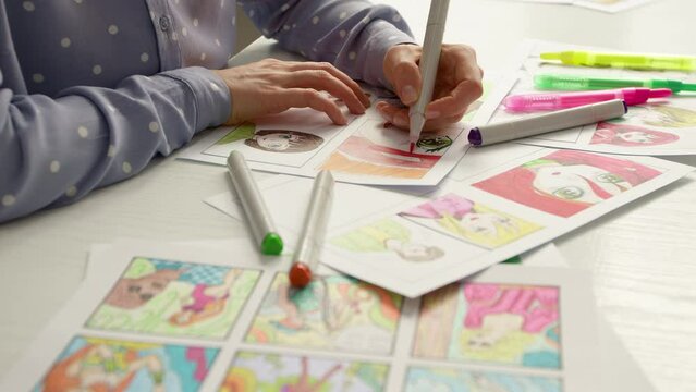 An artist draws a color storyboard of an anime comic. Manga style. The illustrator creates characters on paper.