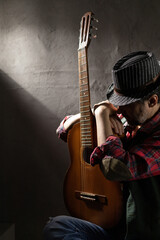 Man holding acoustic guitar. Musician in studio with classic acoustic guitar
