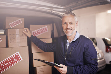 Getting your package delivered on time every time. Portrait of a mature delivery man standing next...