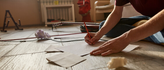 Partial image of man writing text of song at home