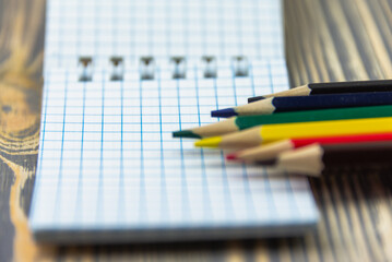 Colored pencils and a notepad with free space for text.