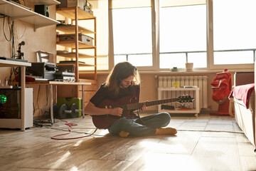 Young caucasian male play electric guitar at home