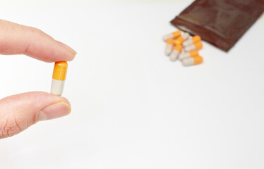finger holded medical drug capsule before  oral take in medical healthcare consumption concept with copy space