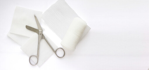 Gauzes, scissors and roll gauze on white background,closed up