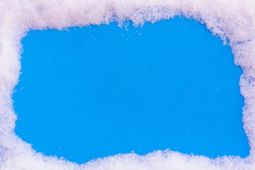 Blue background sprinkled with snow with space for text.