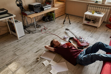 Male songwriter lying and thinking about new song