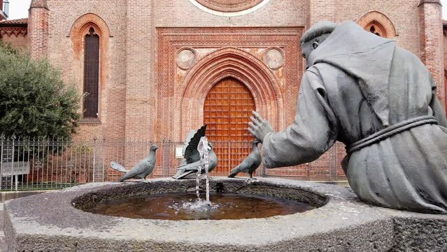 Europe, Italy , Vigevano, Lombardy  March 2022 - Saint Francis of Assisi statue with fountain and pigeons 