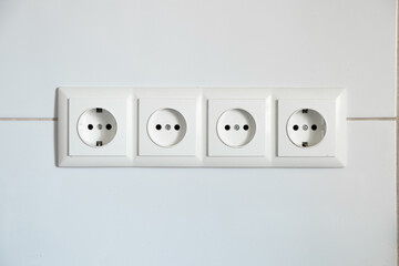 four white sockets on a white tile as a close up background