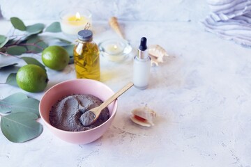 Blue clay, citruses, cream, aromatic oil, healthy tinctures and seashells on a light background, spa, natural ingredients, body care