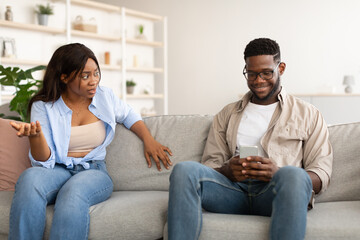 Obraz premium Unhappy Angry Woman Looking At Her Man Using Phone