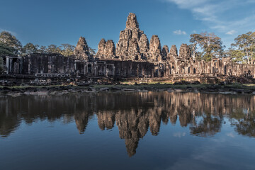 Naklejka premium Ruins of ancient Khmer temple are reflected in pond still water, Angkor Complex, Siem Reap, Cambodia