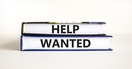Help wanted and support symbol. Concept words Help wanted on books on a beautiful white table white background. Business support and help wanted concept, copy space.