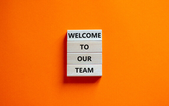 Welcome to our team symbol. Concept words Welcome to our team on wooden blocks on a beautiful orange table orange background. Business, motivational and welcome to our team concept.