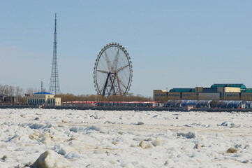 The Amur River during ice drift in spring. Ferris wheel and TV tower in Heihe city, China. Stream...
