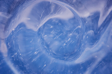 Abstract background. Air bubbles rising from the bottom froze in transparent blue ice. Ice pattern and texture.