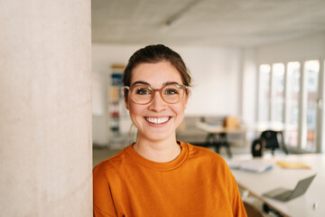 happy businesswoman with glasses in office looking at camera