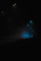 night road in the fog with car headlights