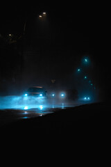 night road in the fog with car headlights