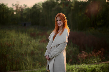 a girl stands in a green forest in spring