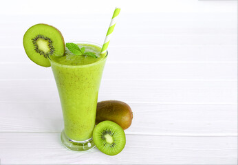 Kiwi yogurt fruit juice smoothie and green kiwi juice drink healthy, delicious taste in a glass for weight loss on a white wooden background.