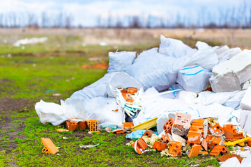 Construction debris on the background of green grass and forest.