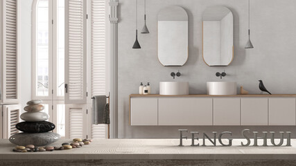 White table shelf with pebble balance and 3d letters making the word feng shui over minimalist bathroom in classic apartment, washbasin, mirrors and decor, zen concept interior design